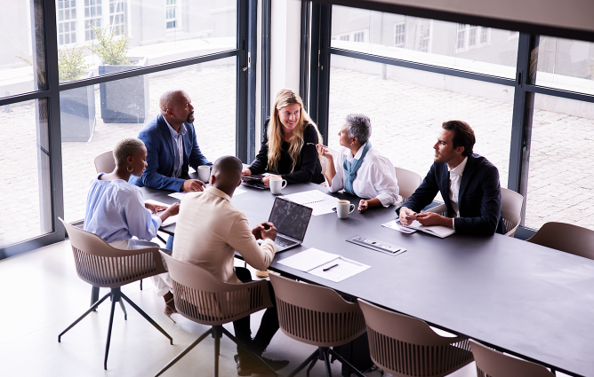 Group of people around an office table discussing